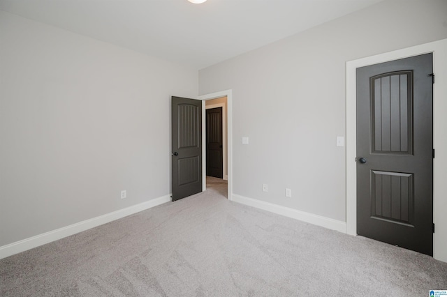 carpeted spare room featuring baseboards