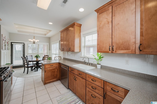 kitchen featuring visible vents, appliances with stainless steel finishes, a tray ceiling, a sink, and light tile patterned flooring