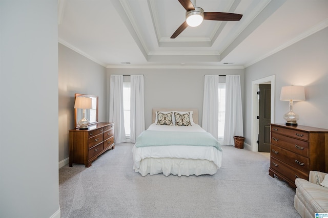 bedroom featuring crown molding, a tray ceiling, baseboards, and light colored carpet