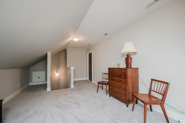 living area featuring lofted ceiling, visible vents, an upstairs landing, baseboards, and carpet