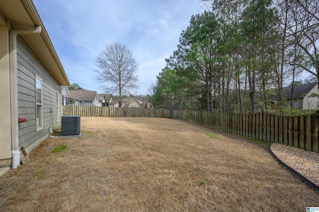 view of yard featuring a fenced backyard and central AC