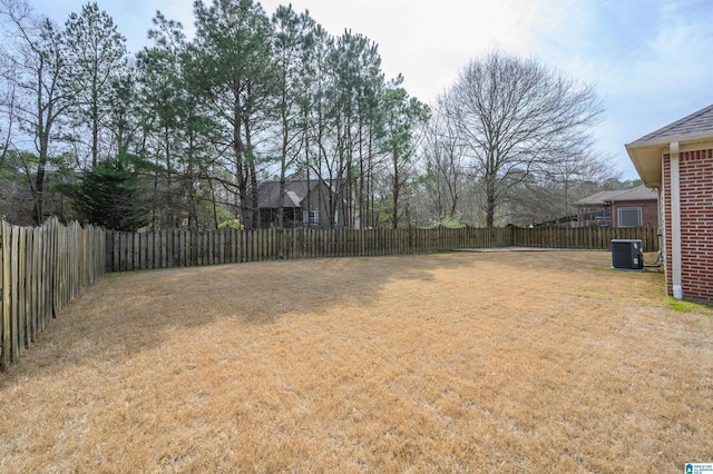 view of yard with central AC and a fenced backyard