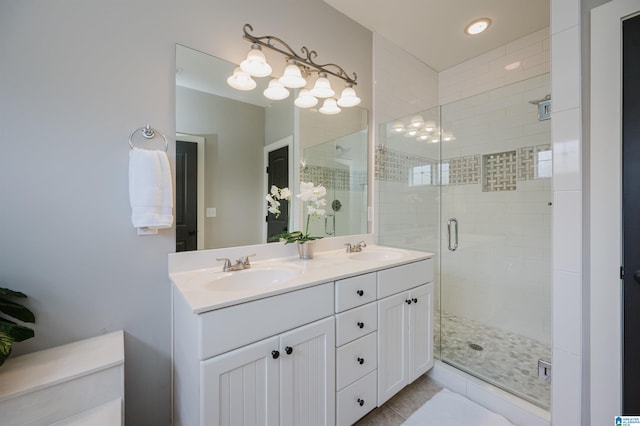 full bathroom featuring a sink, a shower stall, and double vanity