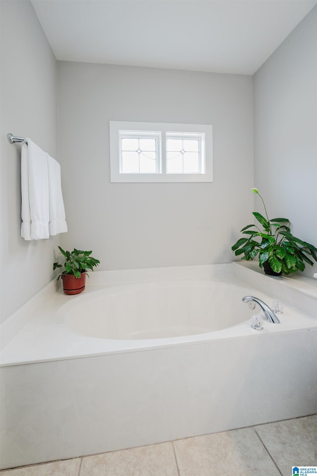 bathroom with tile patterned flooring and a garden tub