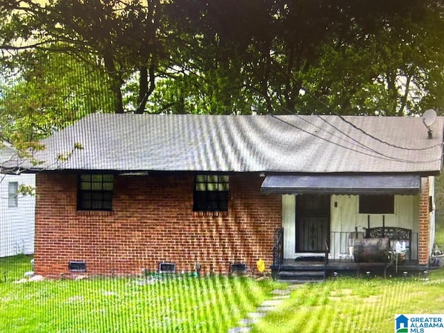 view of front of home with brick siding, crawl space, and a front yard