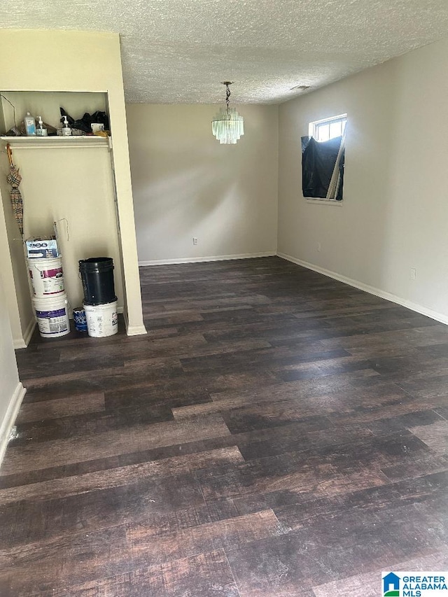 interior space with baseboards, wood finished floors, and an inviting chandelier