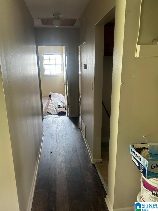 hall with wood-type flooring, baseboards, and an upstairs landing