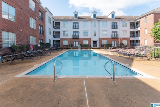 community pool featuring a patio and fence