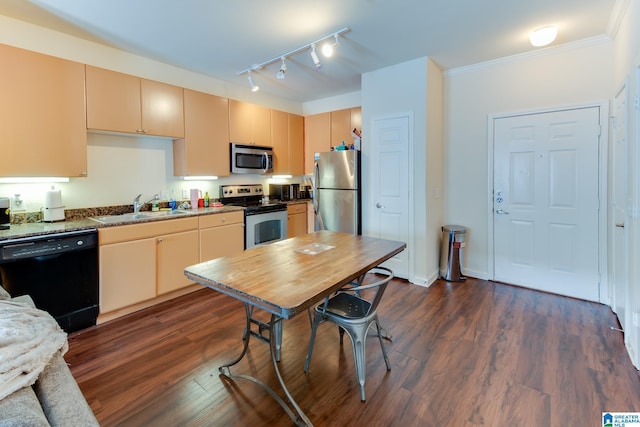 kitchen featuring dark wood finished floors, crown molding, stainless steel appliances, cream cabinets, and a sink