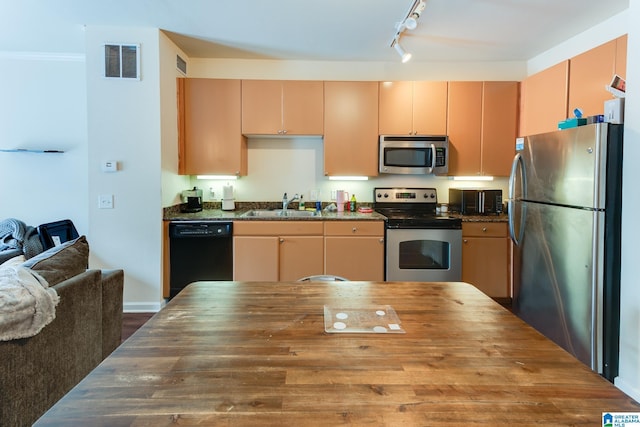 kitchen featuring visible vents, butcher block counters, appliances with stainless steel finishes, rail lighting, and a sink