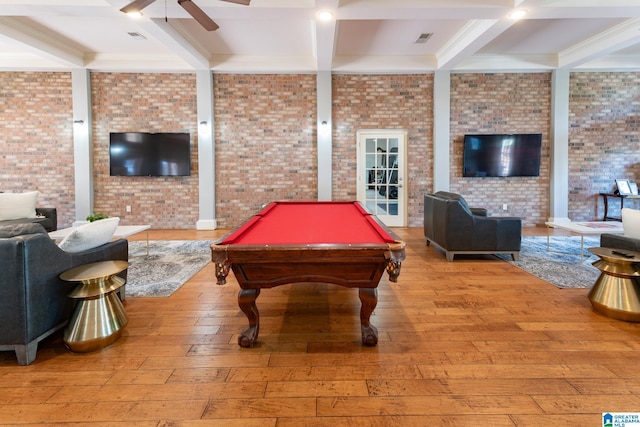 rec room with ceiling fan, hardwood / wood-style flooring, brick wall, visible vents, and beam ceiling