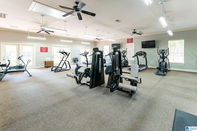 gym with crown molding, visible vents, plenty of natural light, and baseboards