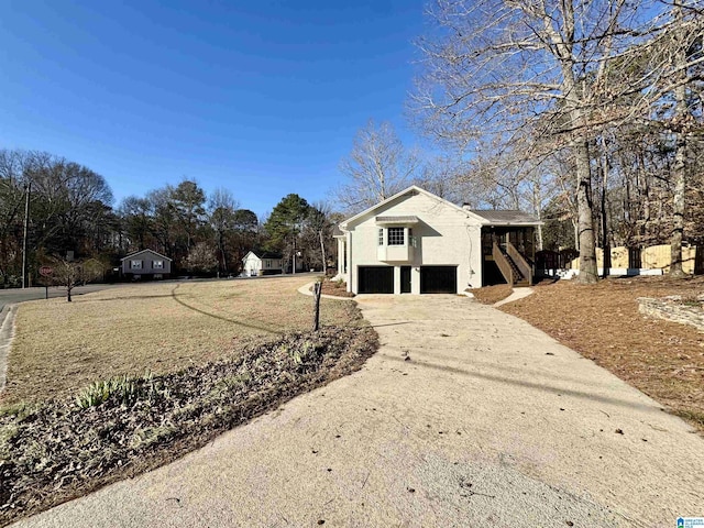 view of side of home with driveway, a garage, and stairway