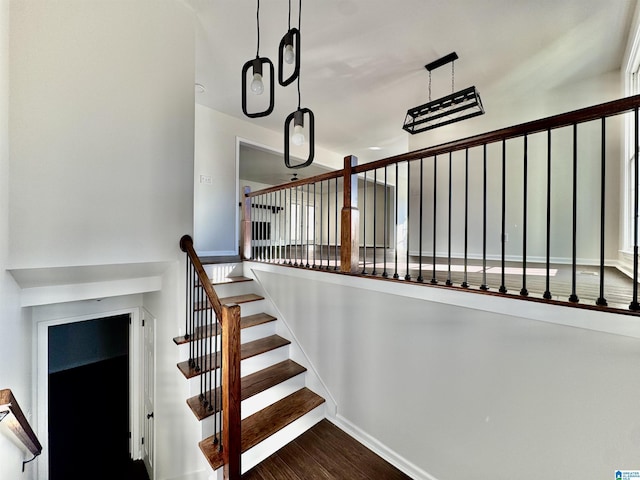 stairway with baseboards and wood finished floors