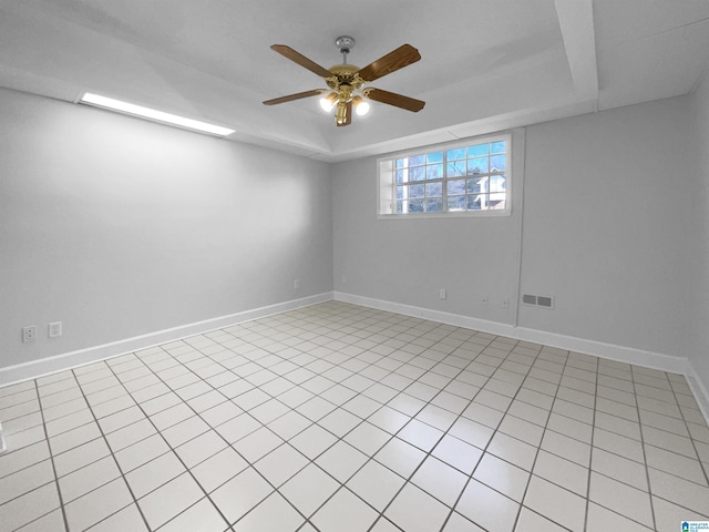 empty room with ceiling fan, baseboards, visible vents, and a raised ceiling