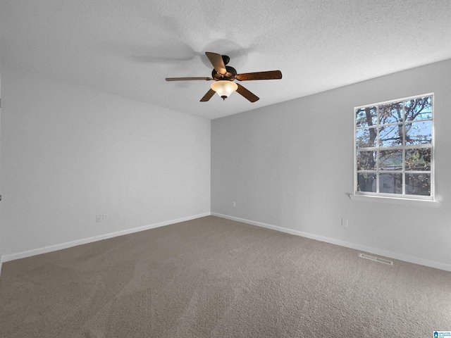 carpeted empty room featuring baseboards, visible vents, and a textured ceiling