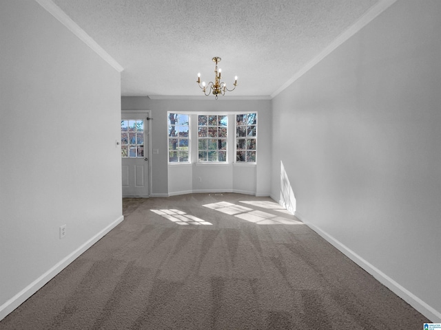 carpeted empty room with crown molding, a notable chandelier, a textured ceiling, and baseboards