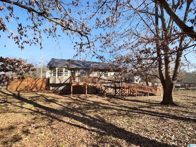 back of property with stairs, fence, and a wooden deck