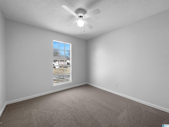 carpeted spare room with a textured ceiling, baseboards, and a ceiling fan