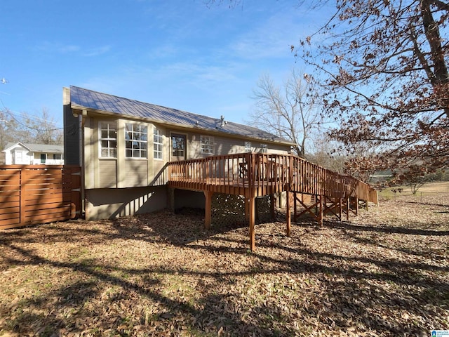 rear view of house featuring metal roof, fence, and a deck