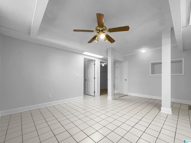 below grade area with light tile patterned floors, ceiling fan, and baseboards