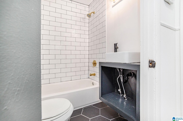 bathroom featuring tile patterned flooring, shower / bath combination, a sink, and toilet