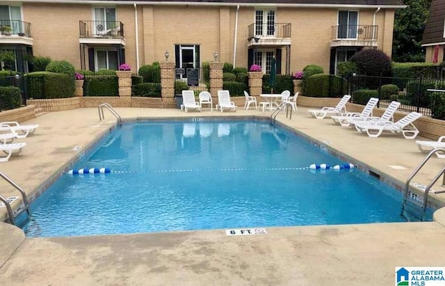 community pool featuring a patio area and fence