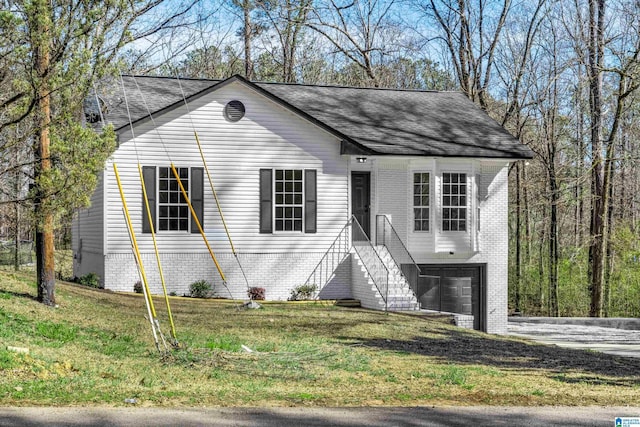 view of front of property featuring a garage, brick siding, and a front yard