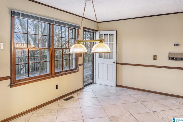 unfurnished dining area with ornamental molding, visible vents, a textured ceiling, and baseboards