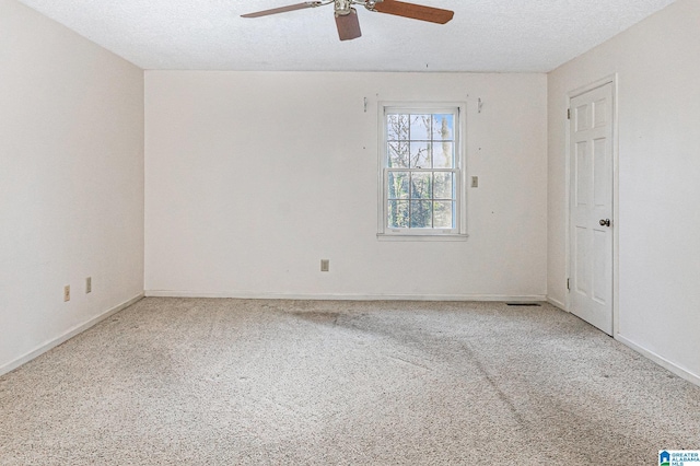 carpeted empty room featuring a ceiling fan, a textured ceiling, and baseboards