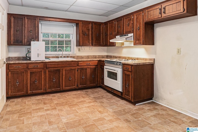 kitchen featuring a paneled ceiling, under cabinet range hood, a sink, stone finish flooring, and white electric range oven