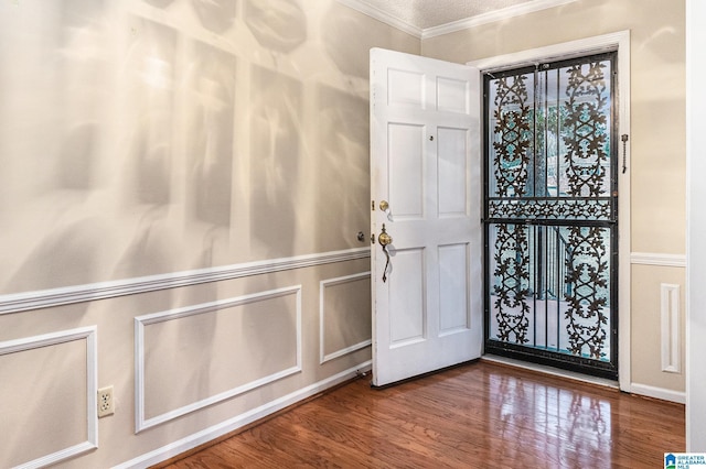 entrance foyer featuring crown molding and wood finished floors