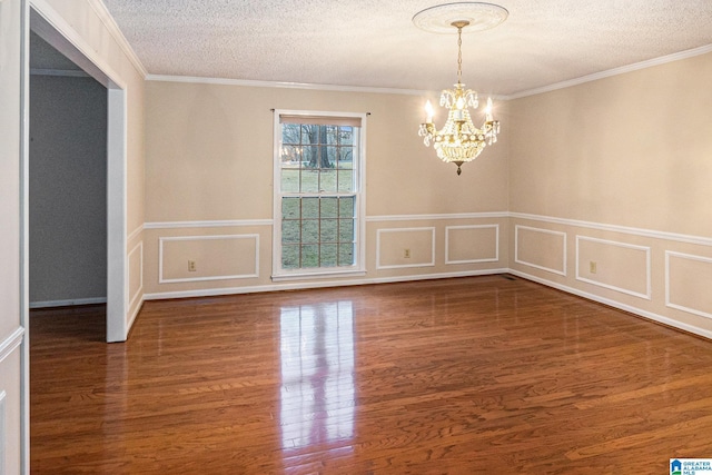 unfurnished room featuring a textured ceiling, crown molding, wood finished floors, and a notable chandelier