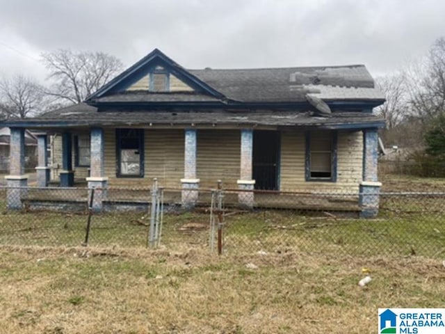 view of front of home with a fenced front yard, a front lawn, and a porch