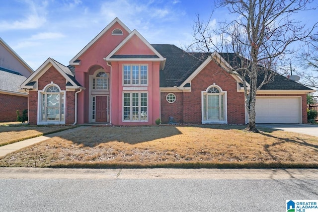 traditional home featuring driveway, a garage, a front yard, and brick siding