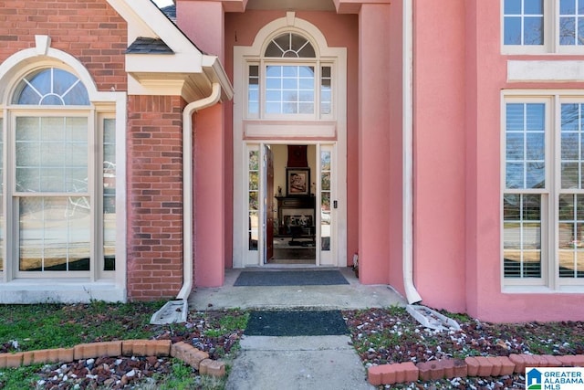 property entrance featuring brick siding and stucco siding