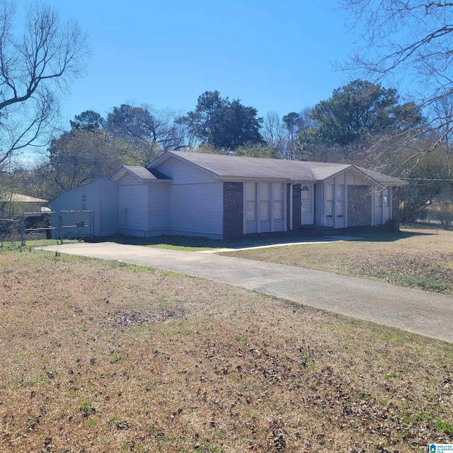 view of front of property featuring driveway, a front lawn, and fence