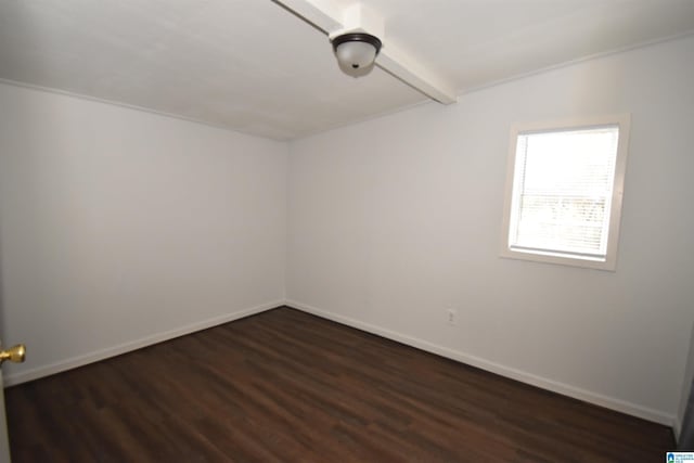 unfurnished room featuring wood finished floors, beam ceiling, and baseboards