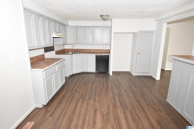 kitchen with dark wood finished floors, dishwasher, under cabinet range hood, and a sink