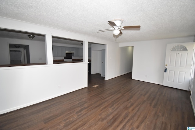 interior space with a ceiling fan, a textured ceiling, baseboards, and wood finished floors