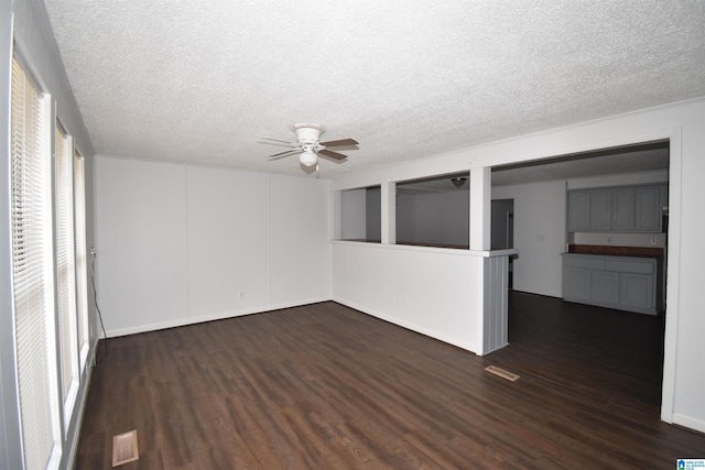 empty room featuring dark wood-style floors, a textured ceiling, and a ceiling fan