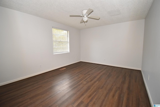 unfurnished room featuring dark wood-style floors, ceiling fan, a textured ceiling, and baseboards