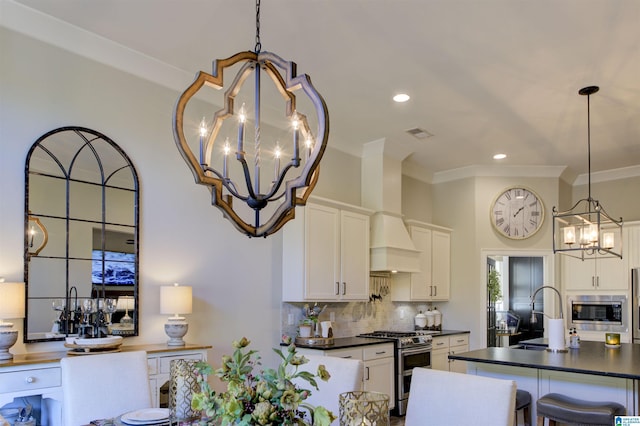 kitchen with a chandelier, appliances with stainless steel finishes, dark countertops, and decorative backsplash