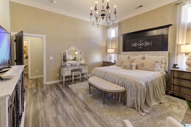 bedroom featuring visible vents, baseboards, ornamental molding, wood finished floors, and an inviting chandelier