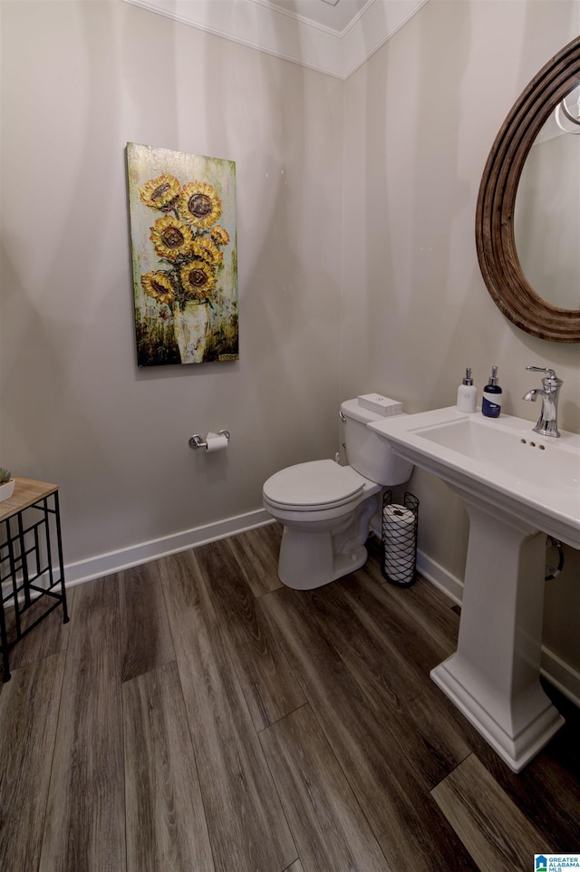 bathroom featuring wood finished floors, toilet, and baseboards