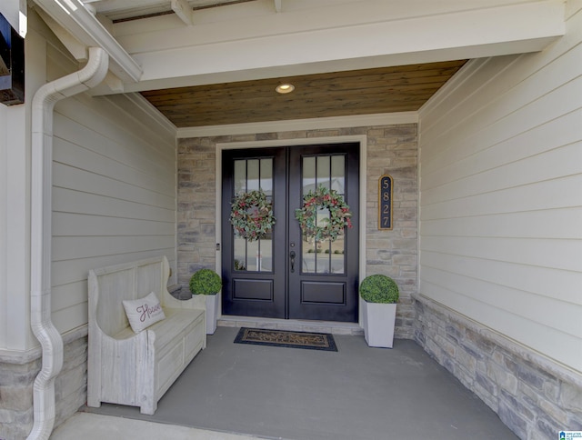 property entrance with stone siding and french doors