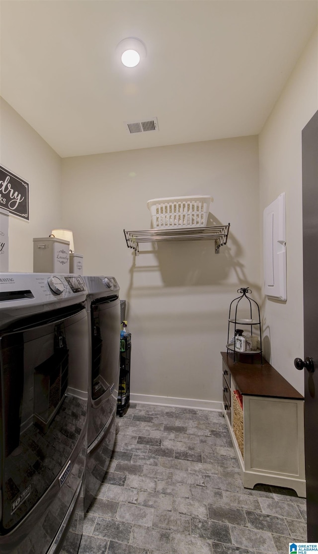 washroom with laundry area, visible vents, washer and clothes dryer, and baseboards