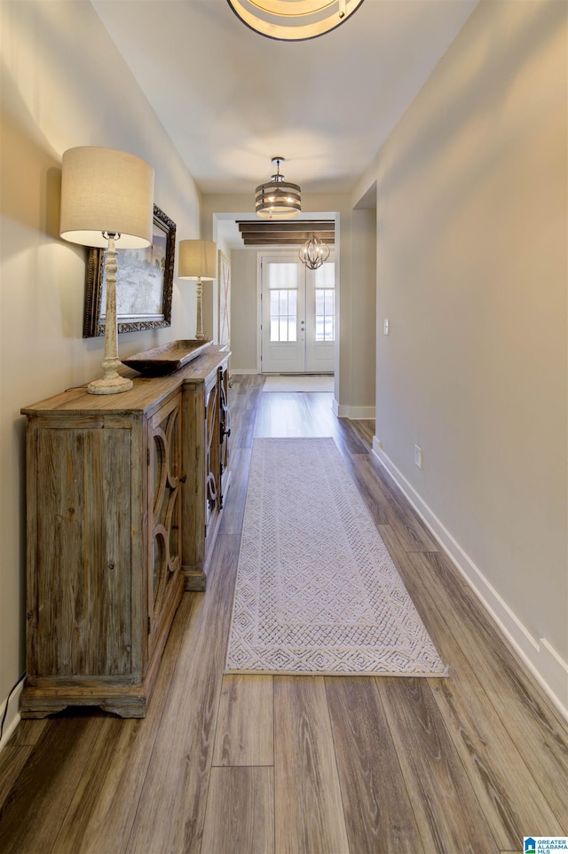 doorway with french doors, dark wood finished floors, and baseboards