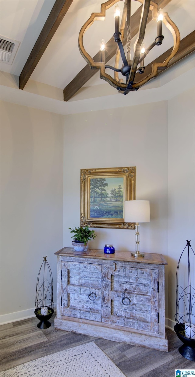 interior details featuring wood finished floors, visible vents, baseboards, beam ceiling, and an inviting chandelier