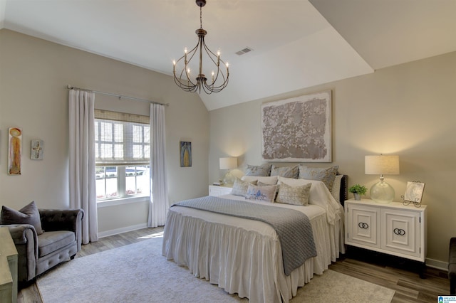 bedroom with a notable chandelier, lofted ceiling, visible vents, light wood-style floors, and baseboards